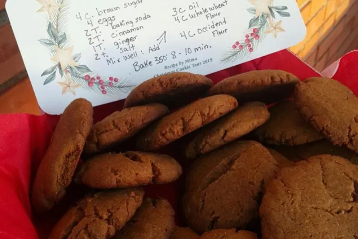 Basket of molasses cookies with recipe card on festive paper in the background.