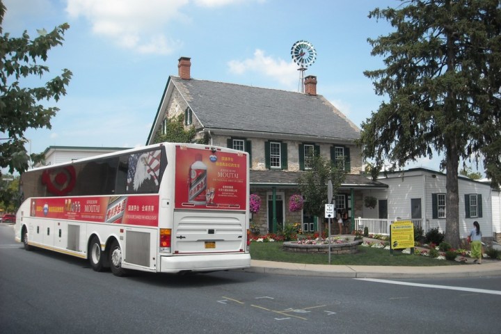 a bus driving down a street in front of a building